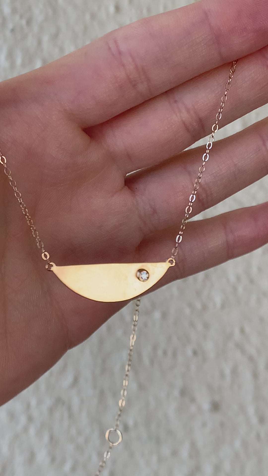 demonstrating the semi circle diamond necklace in motion